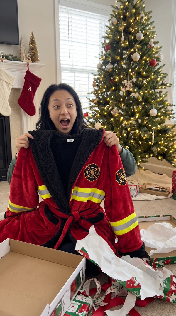 Woman opening gift box pulling out red Turnout Robe Christmas